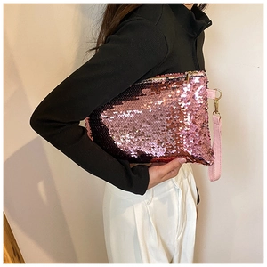 Detail of pink sequin clutch bag showing sparkly texture and secure zipper closure