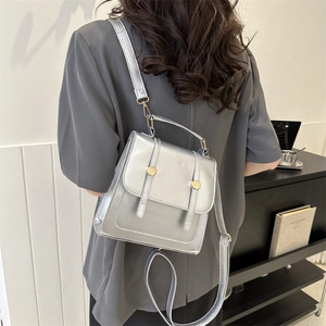Silberner Metallic-Damenrucksack aus PU-Leder mit goldenen Beschlägen am Modell