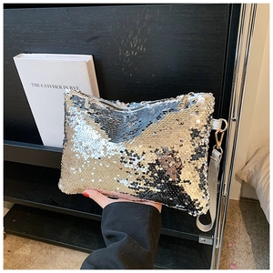 Detail of silver sequin evening clutch bag showing zipper and reflective metallic finish