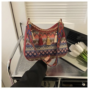 Close-up of bohemian shoulder bag with ethnic geometric patterns and colorful tassels