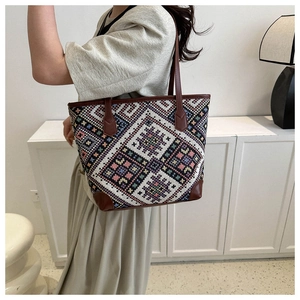 Close-up of ethnic tote bag showing woven geometric patterns and brown leather handles