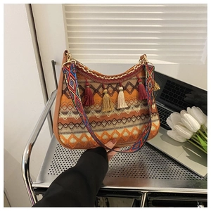 Detail of bohemian woven hobo bag with colorful tassels and wide ethnic shoulder strap