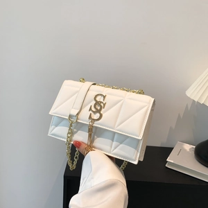 White quilted crossbody flap bag with gold chain strap and elegant tassel detail