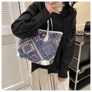 Detailed side view of a large woven plaid tote bag with colorful geometric patterns