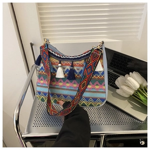 Bohemian woven crossbody bag featuring colorful wave patterns and hanging fringe tassels
