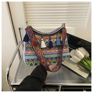 Detail of bohemian hobo bag featuring colorful tassels and embroidered wide strap
