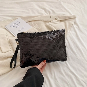 Detail of black sequin clutch bag featuring a wrist strap and metallic gold hook clasp