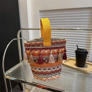 Dettaglio borsa tote boho intrecciata con frange e manico in tela giallo acceso