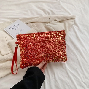 Detailed view of luxury red sequin evening clutch with shiny fringe and top handle strap