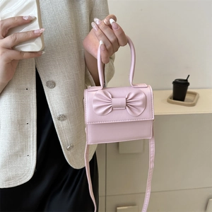 Pink PU leather crossbody bag with a 3D bow design and top handle for women