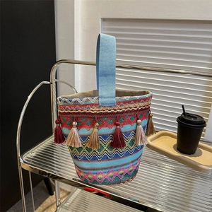 Dettaglio della borsa a secchiello boho intrecciata con motivi geometrici e frange