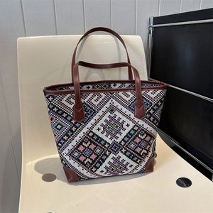 Close-up of ethnic tote bag with colorful geometric patterns on a modern chair