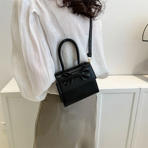 Black mini PU crossbody bag with large bow decoration and adjustable shoulder strap