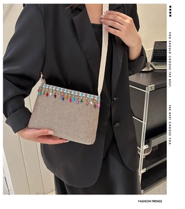 Détail du sac tissé bohème avec glands de perles colorés et broderies géométriques
