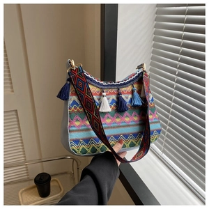 Detail of bohemian woven bag featuring colorful wave patterns and soft cotton tassels