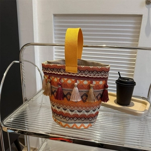 Dettaglio della borsa tessuta in stile etnico con frange colorate e motivi geometrici