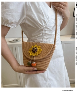 Dettaglio borsa a tracolla in paglia intrecciata con girasole e ciondoli colorati