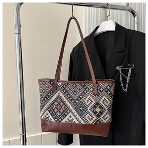 Close-up of geometric woven pattern and dark brown leather trim on the tote bag