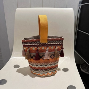 Dettaglio della borsa a secchiello etnica con motivi geometrici e dettagli di nappe