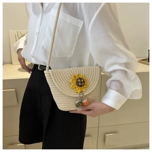 Détail du sac bandoulière en paille avec tournesol et petits pendentifs de fruits