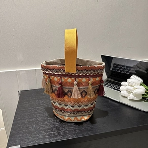 Dettaglio della borsa a secchiello etnica con motivi geometrici e nappe decorative