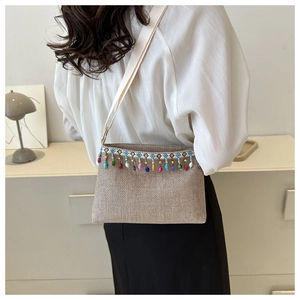 Détail du sac bandoulière tissé bohème avec glands de perles colorés et broderies ethniques