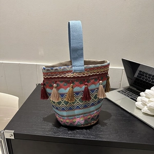 Dettaglio della borsa etnica ricamata con motivi colorati e nappe intrecciate moda