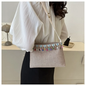 Détail d'un sac à bandoulière tissé ethnique avec des glands de perles colorés et broderies