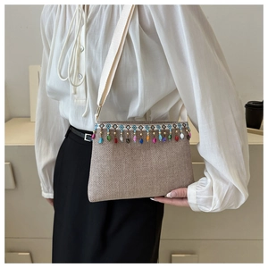 Détail d'un sac bandoulière tissé bohème avec des glands perlés colorés et bordure