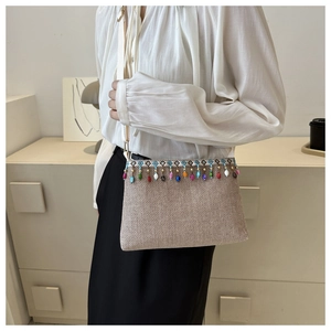 Gros plan détaillé du sac bandoulière tissé ethnique avec perles et bordure à pompons