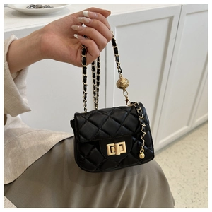 Detail der schwarzen Mini-Stepptasche mit goldener Kette und kugelförmiger Verstellschnalle