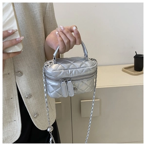 Detail of silver quilted leather mini bucket bag with chain strap and dual zipper closure