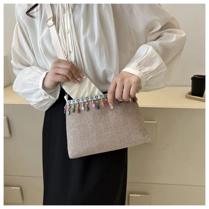 Vue détaillée du sac enveloppe tressé avec perles colorées et longue bandoulière