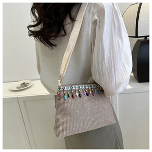 Détail du sac bandoulière bohème tissé avec glands de perles colorés et broderie