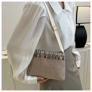 Détail d'un sac tissé ethnique avec glands en perles colorées et sangle brodée