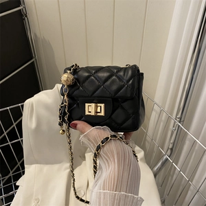 Detail der schwarzen gesteppten Mini-Tasche mit goldener Kugelkette und Drehverschluss