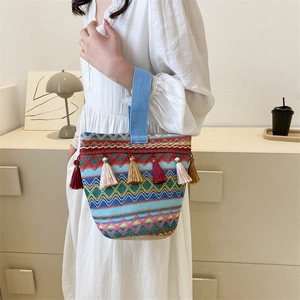 Dettaglio della borsa tessuta bohémien con motivi geometrici colorati e nappe decorative