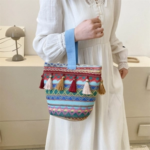 Dettaglio di borsa etnica tessuta colorata con frange e ampio manico in tessuto azzurro
