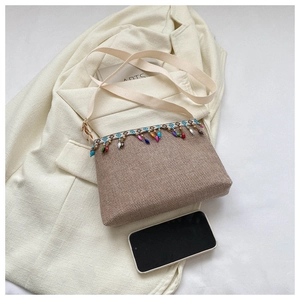 Détail du sac à bandoulière bohème tissé avec breloques en perles et sangle en toile