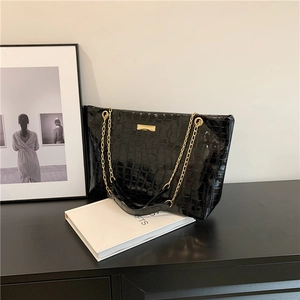 Chic black crocodile embossed tote bag with gold chain straps and spacious interior design