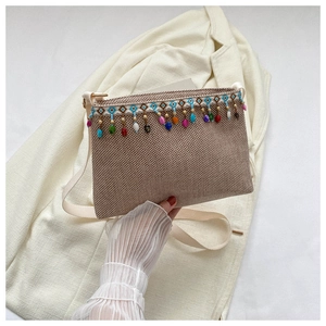 Détail du sac à bandoulière bohème avec perles colorées et texture tissée élégante