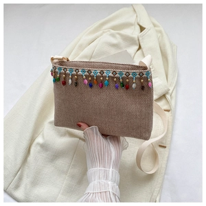 Vue détaillée du sac tissé bohème avec franges de perles ethniques et tissu texturé