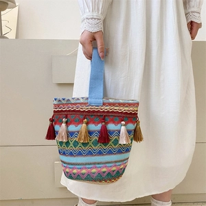 Dettaglio della borsa tote intrecciata in stile boho con frange vivaci e motivi geometrici
