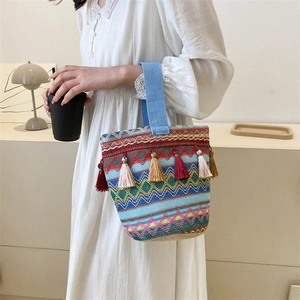 Dettaglio della borsa tote intrecciata bohémien con motivi geometrici e frange colorate
