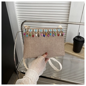 Vue détaillée d'une pochette tissée ethnique avec des glands en perles multicolores