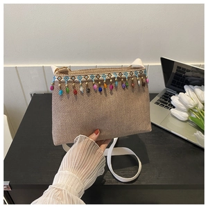 Vue détaillée du sac en paille bohème avec glands de perles colorées et sangle tissée