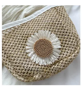 Macro detail of hand-woven straw bucket bag featuring a large white daisy flower ornament