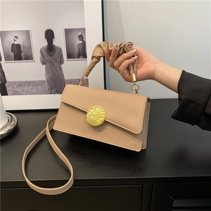 Elegant beige ruched handle handbag with golden circular lock and thin shoulder strap