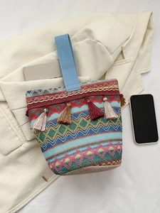 Dettaglio della borsa tessuta a mano con motivi geometrici colorati e nappe vivaci