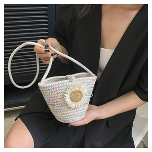 Détail d'un sac seau tissé coloré avec fleur en tricot et fermoir en perles fines